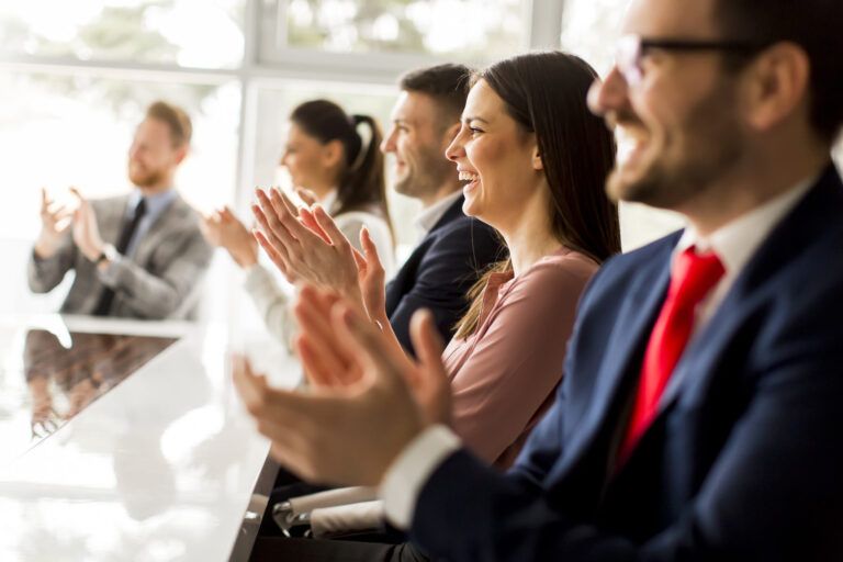 Happy group of businesspeople clapping in office